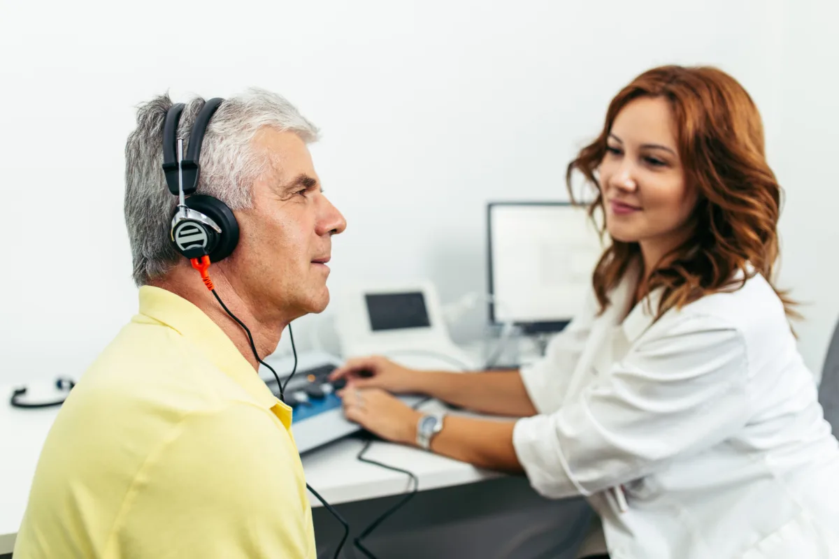 Audiologist carrying out a hearing test at home